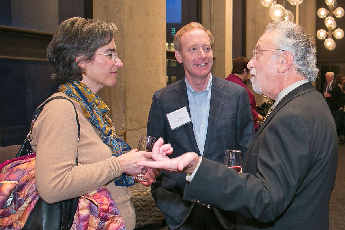 Norm Arkans, UW associate vice president, media relations and communications, talks with Irene Plenefisch, Microsoft government affairs director, and Brad Smith, Microsoft president and chief legal officer, at a pre-event reception.